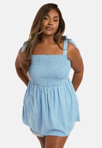 Hellblaues, ärmelloses Oberteil mit gerafftem Oberteil, quadratischem Ausschnitt, Bindeträgern und weißen Punkten. Fließender, strukturierter Stoff.