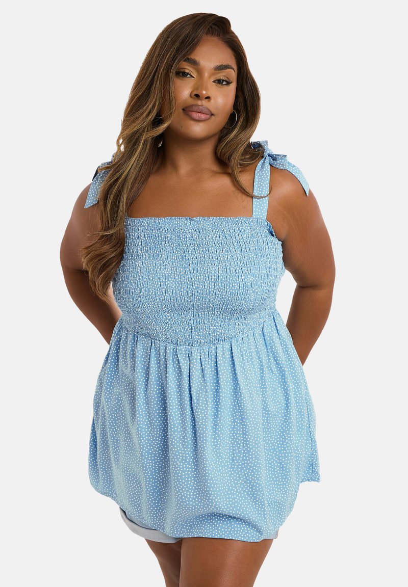 Hellblaues, ärmelloses Oberteil mit gerafftem Oberteil, quadratischem Ausschnitt, Bindeträgern und weißen Punkten. Fließender, strukturierter Stoff.