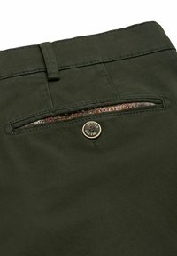 Grüne Hosen mit glatter Textur, ausgestattet mit einer Gesäßtasche mit dekorativem Muster und einem goldenen Knopfdetail.