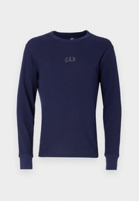 T-shirt à manches longues bleu marine en tissu côtelé. Caractérisé par un col rond et un logo GAP subtil dans une teinte plus foncée sur la poitrine.
