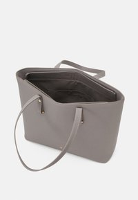 Bolso tote gris hecho de material sintético con doble asa, parte superior abierta, textura suave y detalles en tono dorado. El interior está forrado.