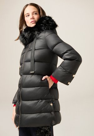 Chaqueta acolchada negra con cuello de pelo sintético, que presenta un cierre con cremallera, bolsillos laterales y puños acanalados con acentos de botones.