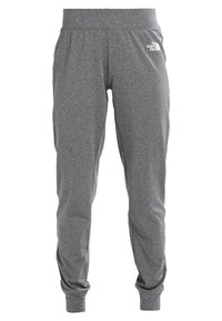 Szare spodnie dresowe wykonane z miękkiego, elastycznego materiału, z elastycznym pasem i zwężanymi nogawkami. Na lewej udzie znajduje się małe białe logo.
