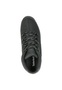 Zapato textil negro con parte superior texturizada, puntera reforzada y detalles de malla. Presenta cordones negros y una plantilla con marca.