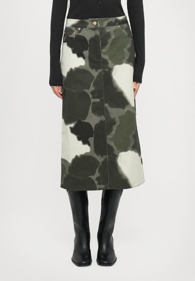 Midikleid mit einem Camouflage-Muster in Grün-, Schwarz- und Cremetönen. Hergestellt aus Jeansstoff mit Fronttaschen und kupferfarbenen Knöpfen.