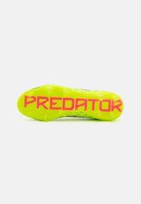 Semelle de crampons de football Predator en jaune vif avec le texte "PREDATOR" en rose, dotée de crampons texturés pour une traction améliorée et une optimisation des compétences.