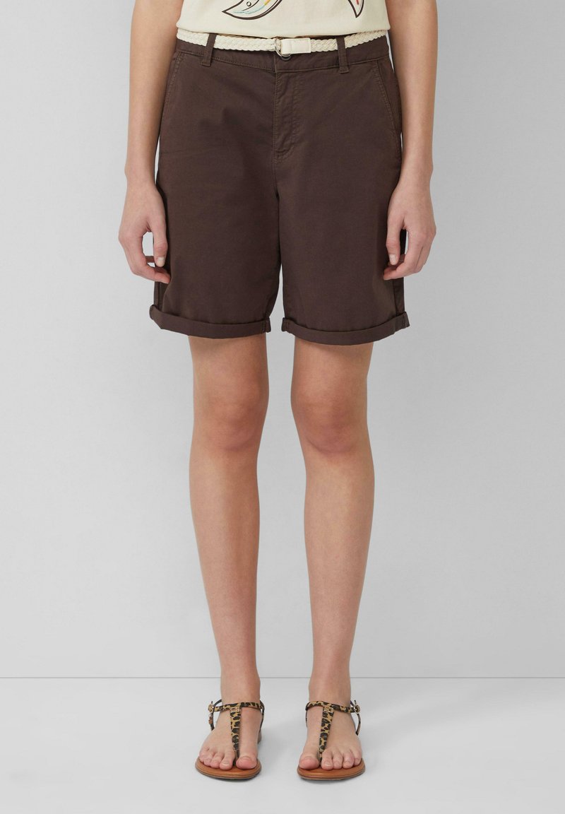 Bruine katoen shorts met opgerolde omslagen, gecombineerd met een beige gevlochten riem en sandalen met luipaardprint. Eenvoudig ontwerp, geschikt voor casual kleding.