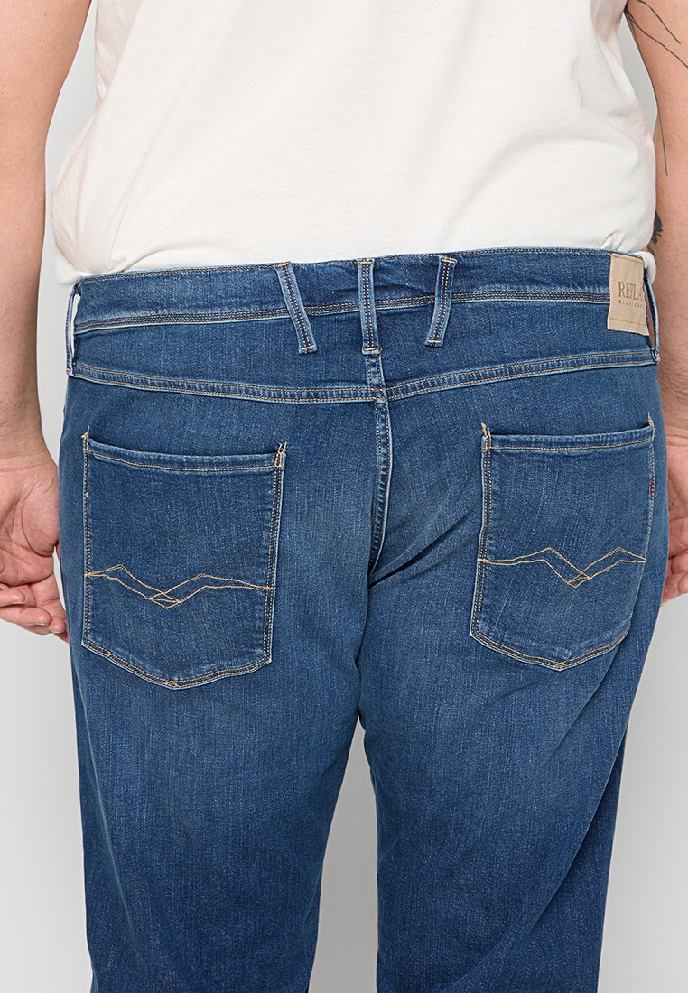 Heren blauwe denim jeans met een rechte snit, voorzien van twee achterzakken met gele stiksels en een leren merklabel op de tailleband.