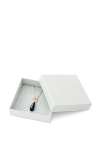 Schwarze Anhängerkette mit Goldkette, präsentiert in einer hellgrauen, strukturierten Geschenkbox. Beinhaltet einen runden Akzent an der Kette.
