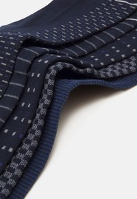 Ναυτικές κάλτσες με ποικιλία σχεδίων: ρίγες, κουκίδες και καρό. Μαλακή, πλεκτή υφή με αντιθέτοντες γκρι και μπλε τόνους.