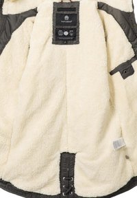 Lined jacket with a cream, fluffy interior. Outer fabric is dark gray, featuring a label and lace-up detail at the bottom.