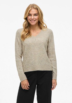 Pull en V en beige clair avec un motif en losanges texturé, manches longues et ourlet côtelé ; matière tricotée douce.