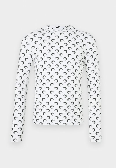 Chemise ajustée à manches longues blanche avec un motif de croissant de lune noir. Texture lisse, col montant et tissu extensible.