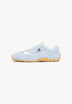 Light blue low-top sneaker with white laces, beige accents, gum sole, and small Tommy Hilfiger logo on the side panel.