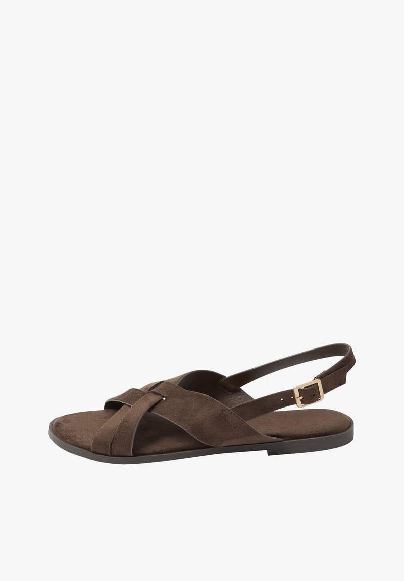 Braune flache Sandale aus Wildleder mit gekreuzten Riemen, verstellbarer Schnalle am Knöchel und offenem Zehendesign auf schwarzer Sohle.