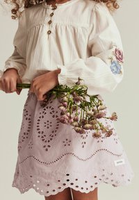 Leichte, beigefarbene Bluse mit langen Ärmeln, dekorativen Knöpfen und floralen Stickereien. Der Lavendelkilt hat Lochstickereien und einen gewellten Saum.