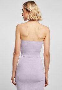 Lila geribbelde gebreide jurk met een strapless ontwerp, aansluitende lijfje en een tapslopende rok. Gladde textuur en ingetogen silhouet.