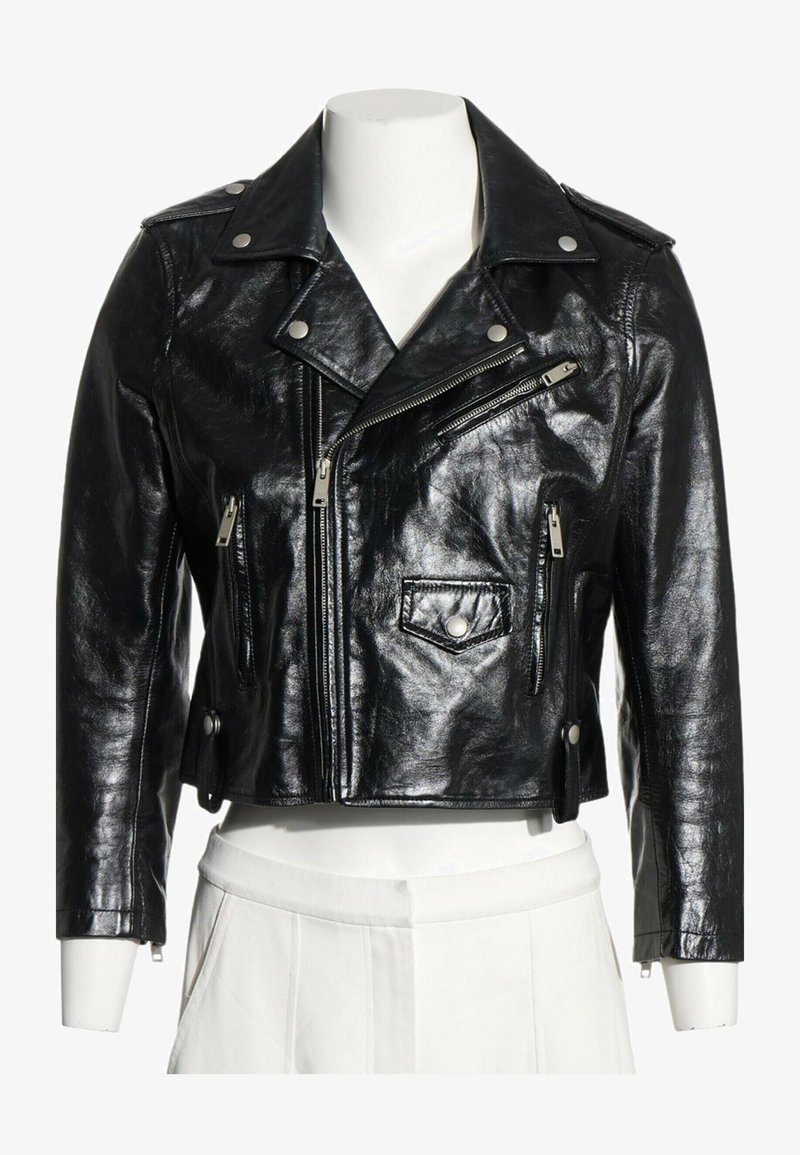 Veste en cuir noire courte style motard avec fermetures éclair argentées, boutons-pression et large col à revers sur un torse de mannequin blanc.