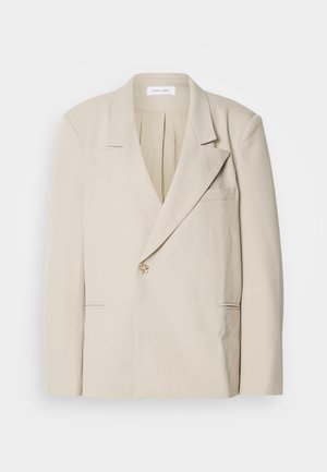 Beige tailored blazer with structured shoulders, single front button closure, and two front pockets. Smooth fabric with a slightly matte finish.