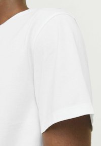 Hvid bomulds t-shirt med rund halsudskæring og korte ærmer, der har en glat tekstur og en afslappet pasform.