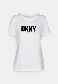 Vitt bomullströja med en svart broderad "DKNY" logotyp på framsidan. Klassisk rund hals, korta ärmar och normal passform.