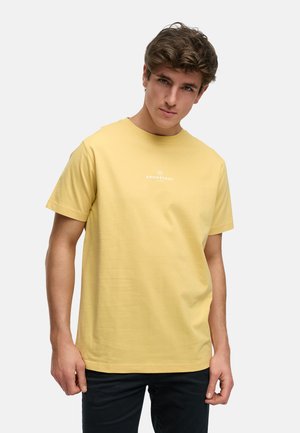 Gelbes Baumwoll-T-Shirt mit Rundhalsausschnitt und kurzen Ärmeln. Verfügt über ein kleines weißes Logo auf der Brust. Glatte Textur und lässige Passform.