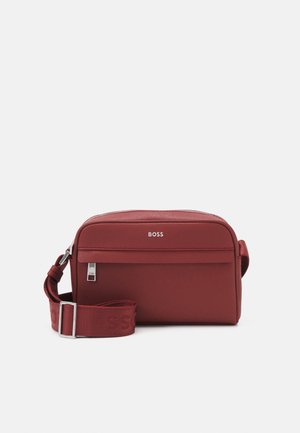 Rode rechthoekige crossbodytas met een voorvak met rits, verstelbare band en een "BOSS"-logo aan de voorkant in het midden.