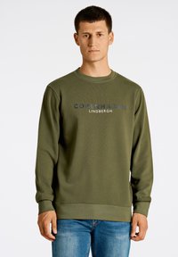 Olivgrön sweatshirt i ett mjukt, texturerat tyg. Har rundad halsringning och ribbade ärmslut, med "COPENHAGEN LINDBERGH" tryckt i marinblått.