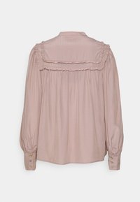 Långärmad blus i ljust rosa tyg, med rynkad krage och insamlad baksida. Knappdetaljer på ärmarna framhäver designen.