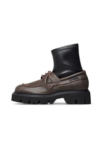 Scarpa in pelle marrone con una robusta suola in gomma nera e una parte superiore nera che ricorda la parte di un stivale. Presenta lacci e dettagli in metallo.