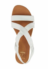 White leather sandals featuring crossed straps, a smooth texture, and a cushioned brown insole. Stamped logo on the footbed.