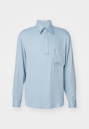 Light blue long-sleeve shirt made of smooth fabric, featuring a fold-down collar, three buttons, and a left chest pocket with contrast stitching.