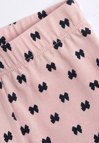 Lichtroze stof met zwarte vlinderpatronen, voorzien van een elastische tailleband en een gladde, zachte textuur die geschikt is voor comfortabel dragen.