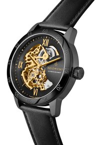 Reloj de movimiento automático con caja negra y correa de cuero. Presenta una esfera esqueleto dorada, fondo negro y marcadores de números romanos.