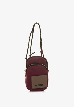 Bordeaux nylon schoudertas met een ritsvak, zwarte afwerking en een verstelbare koordriem. Voorzien van een bruine logo patch aan de voorkant.