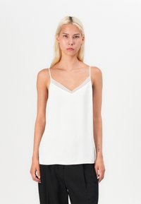 Weiße Satin-Camisole mit V-Ausschnitt und transparentem Mesh-Besatz. Dünne Träger und eine lockere Passform ergänzen die glatte Textur.