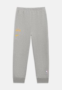 Grå sweatpants lavet af bomuld med elastisk talje, prydet med gule Lakers og Nike-logoer på venstre ben, ribbede manchetter ved anklerne.