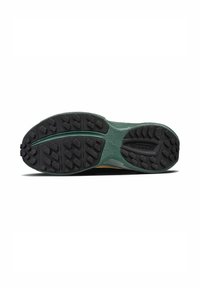 Semelle de chaussure verte avec un caoutchouc noir texturé, présentant des crampons multidirectionnels pour une meilleure adhérence et un design ondulé et rayé sur la semelle intermédiaire.