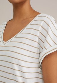 Ribaga v-kaelusega särk valge ja beeziga. Pehme, kerge kangas lühikeste rullitud varrukatega ja lõdva istuvusega, horisontaalsete triipudega.