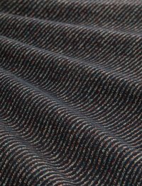 Tissu texturé en bleu marine foncé avec des lignes ondulées, intégrant des accents rouges et crème. Matériau doux et tissé avec des motifs en relief distincts.