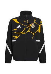 Zwarte jas met een hoge kraag en een gele bliksemschichtdesign. Voorzien van een Real Madrid-logo en witte strepen op de mouwen. Ritssluiting.