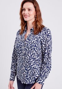 Camicia blu navy con motivo di piume bianche, con abbottonatura davanti e doppie tasche sul petto, realizzata in tessuto leggero.