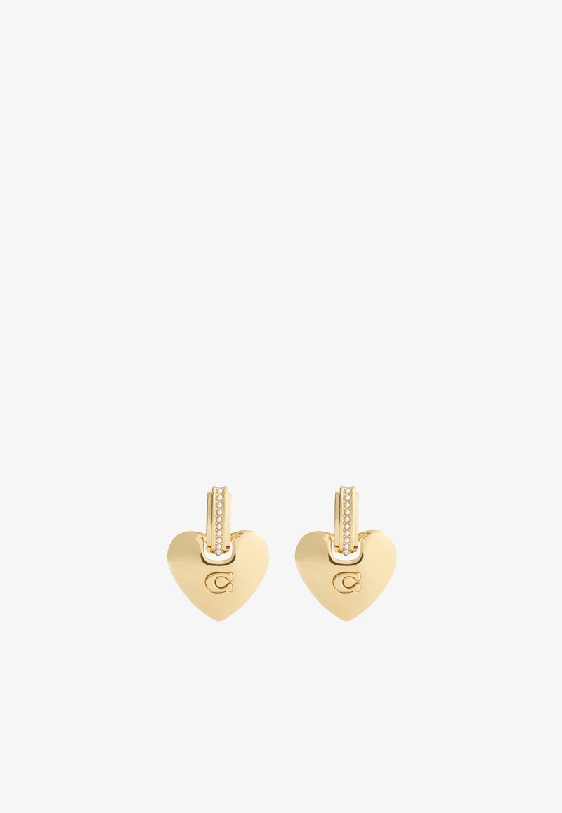 Gold heart-shaped earrings with a small accentuated lever back and a patterned detail at the top. Features a logo engraved on one side.