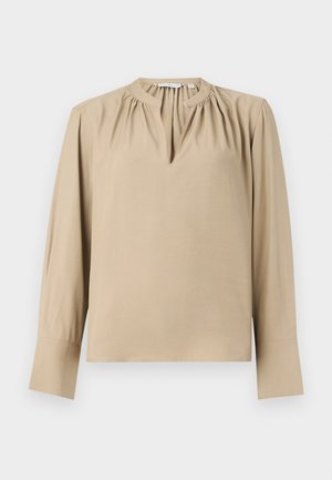 Béžová blúzka s dlhým rukávom a výstrihom v tvare kľúčovej diery, so zberaným detailom na pleciach a priame strih. Hladká tkanina s manžetami na rukávoch.