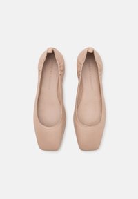 Scarpe flat nude in pelle liscia, con punta arrotondata e bordi elastici, caratterizzate da un design minimalista a forma quadrata.