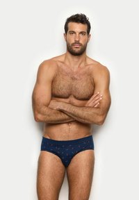 Bóxers de algodón en color navy con un patrón de pequeños pimientos rojos, con una banda elástica y un ajuste ceñido. Fondo liso.