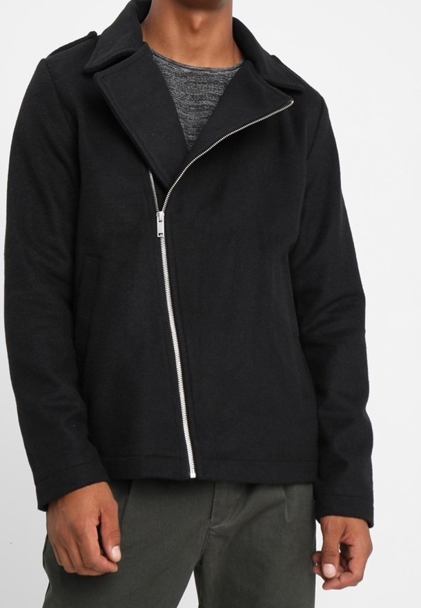 Musta takki, jossa on vetoketjukiinnitys ja suuri kaulus, valmistettu teksturoidusta kankaasta. Muotoilussa on pitkät hihat ja rento istuvuus.