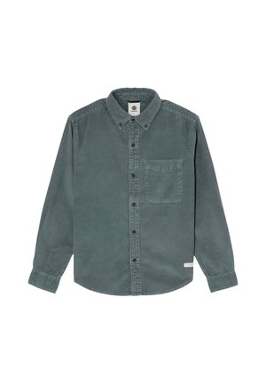 Chemise en velours côtelé verte à manches longues, boutonnée sur le devant, avec poche poitrine et col en pointe, posée à plat sur un fond blanc.