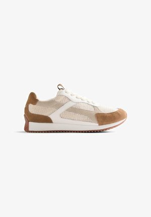 Scarpa da ginnastica bassa con rete bianca e sovrapposizioni in camoscio beige, lacci bianchi e suola in gomma marrone con motivo a tasselli.