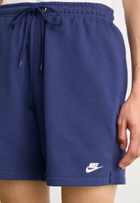 Námořnické modré kraťasy Nike vyrobené z měkké bavlněné směsi, s elastickým pasem na šňůrku, bočními kapsami a bílým logem.